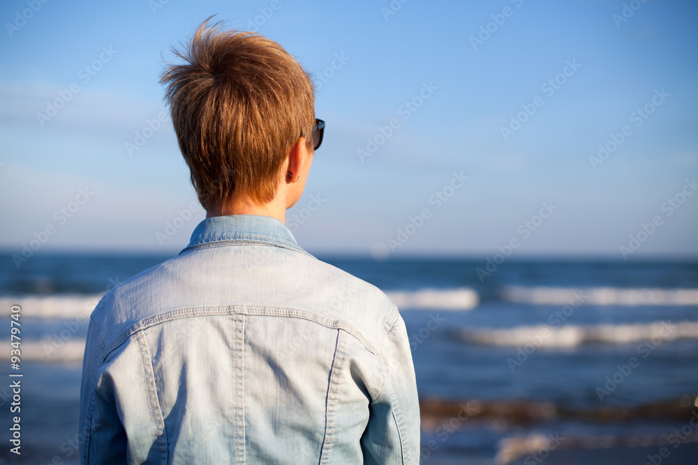 Mujer en la playa esperando y mirando al horizonte Mujer en la playa esperando y mirando al horizonte