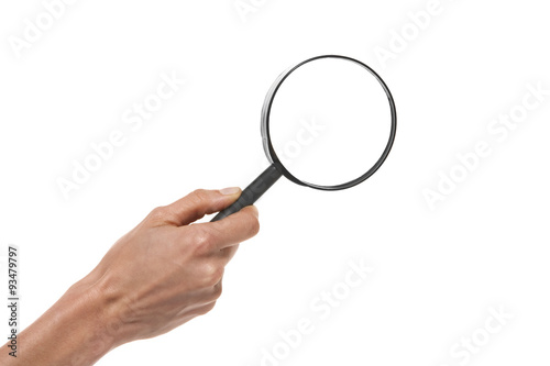 Hand holding a magnifying glass over white background.