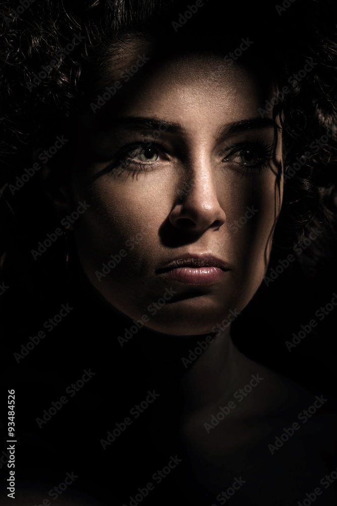 Young beautiful woman in dark shadow and ray of light Young beautiful woman in dark shadow and ray of light