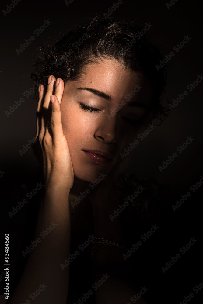 Young beautiful woman in dark shadow and ray of light Young beautiful woman in dark shadow and ray of light