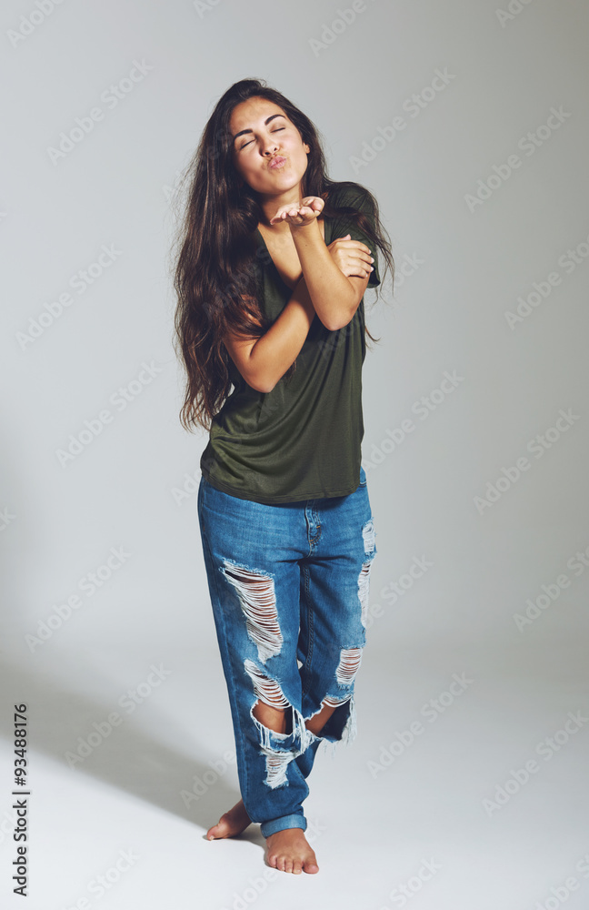 Playful young woman blowing a kiss Playful young woman blowing a kiss