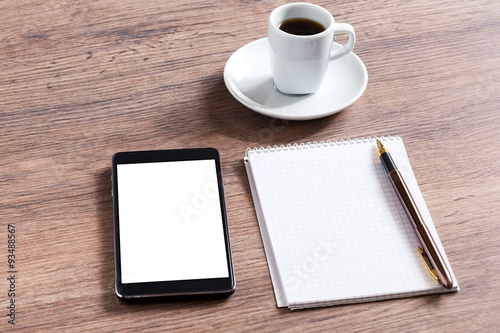 Notebook with pen, smart phone and coffee cup