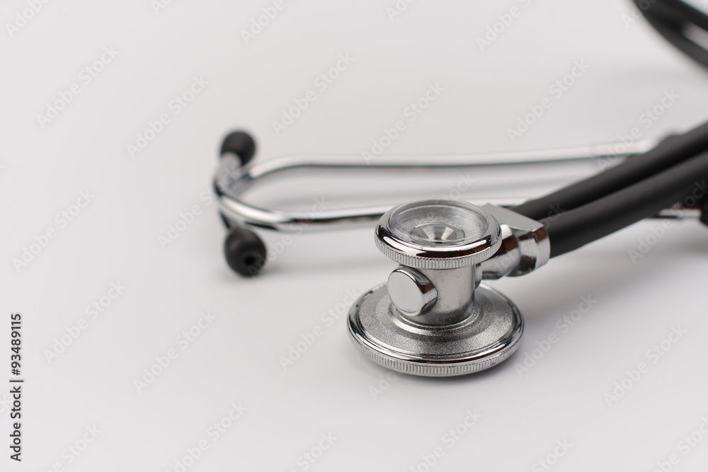 Black stethoscope on white background, close up view. Black stethoscope on white background, close up view.