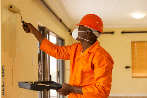 african construction worker painting the wall