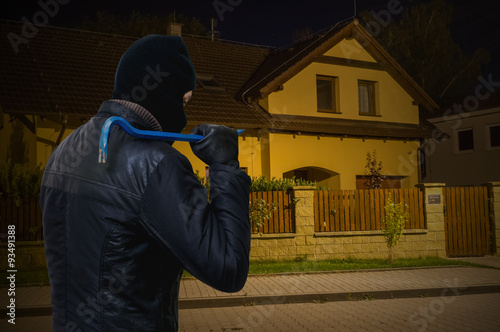 Masked bandit or criminal is going to rob house at night. photo