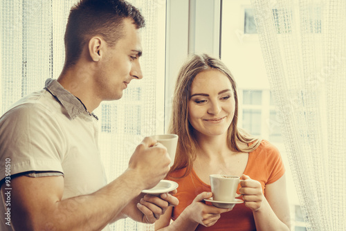 young couple drinking tea or coffee at home