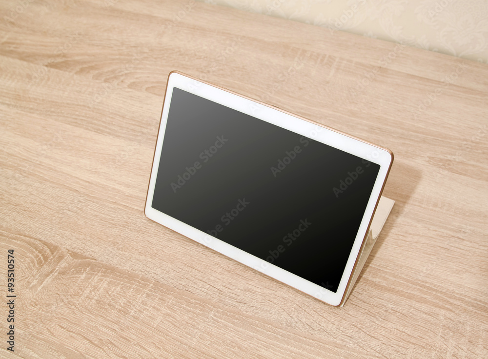 White tablet on the wooden table White tablet on the wooden table