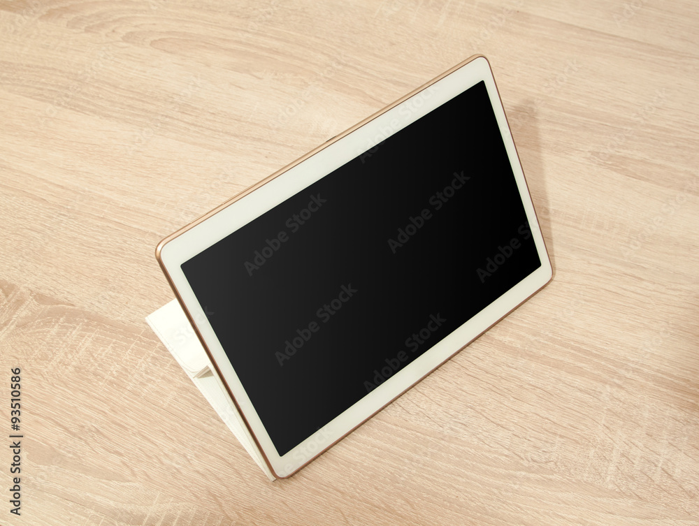 White tablet on the wooden table White tablet on the wooden table
