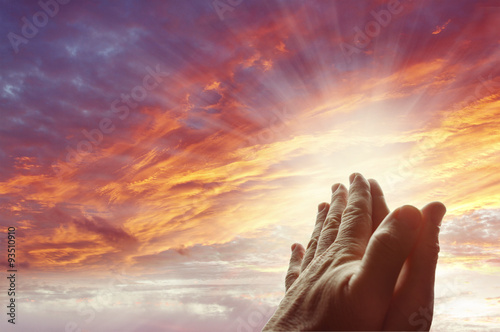 Hands together praying. Bright sky light. Prayer