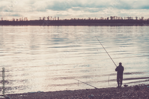 Fisherman on the river with a fishing rod