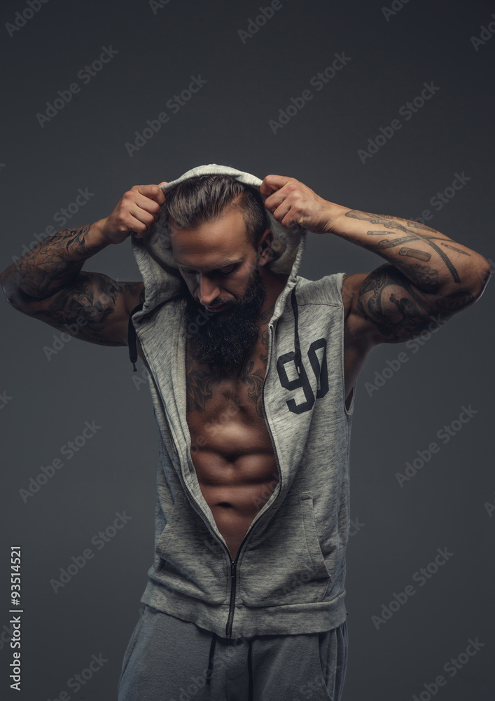 Brutal tattooed man in grey hoodie. Brutal tattooed man in grey hoodie.
