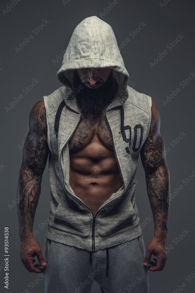 Gangsta tattooed muscular man in a hood.