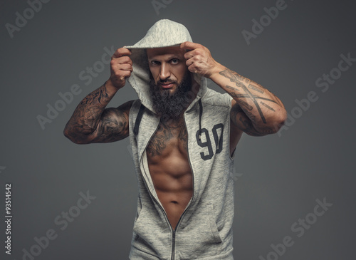 Gangsta tattooed muscular man in a hood. © Fxquadro