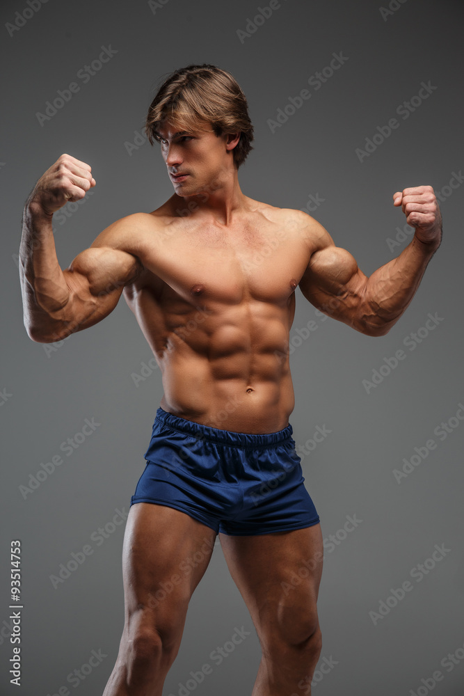 Strong muscular bodybuilder showing his body.
