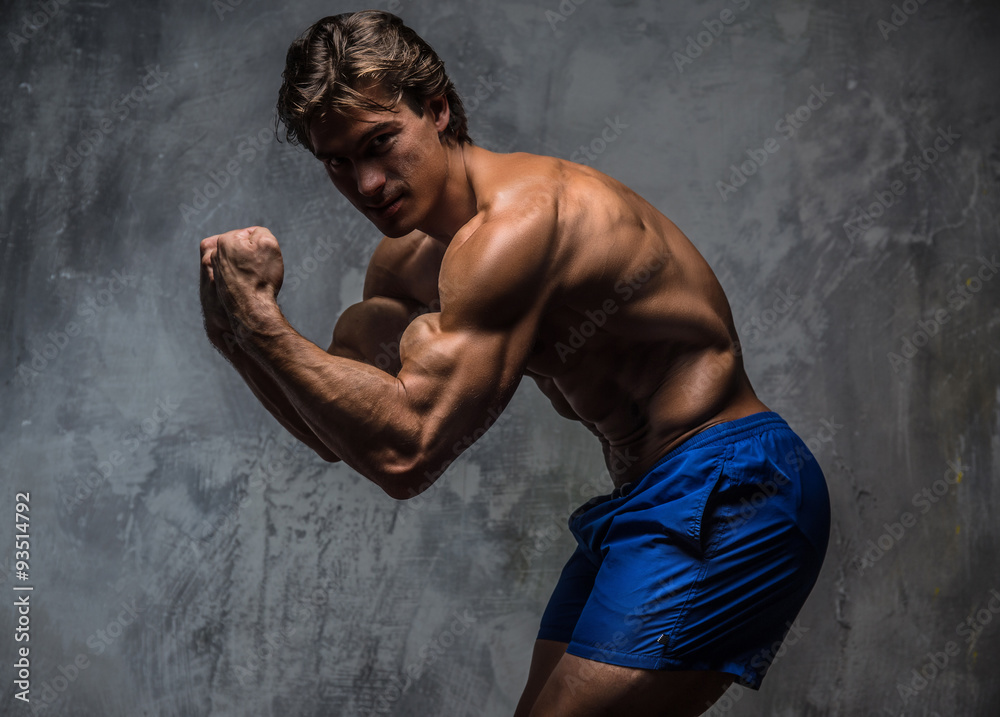 Fototapeta premium Strong muscular bodybuilder showing his body.