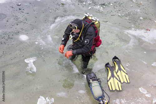 diver preparing for the ice-diving under the frozen surface of lake