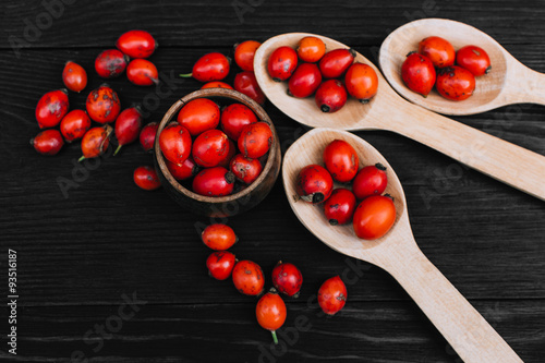 Hawthorn on wooden rustic table background. Rose hips haw fruit of the dog rose