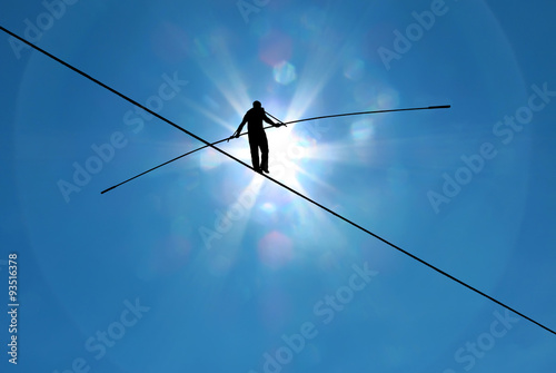 Fotografia, Obraz Highline walker in blue sky concept of risk taking and challenge