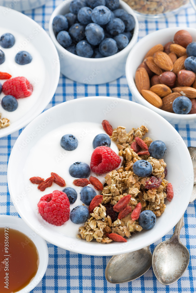 delicious breakfast with granola, berries and yogurt, vertical delicious breakfast with granola, berries and yogurt, vertical