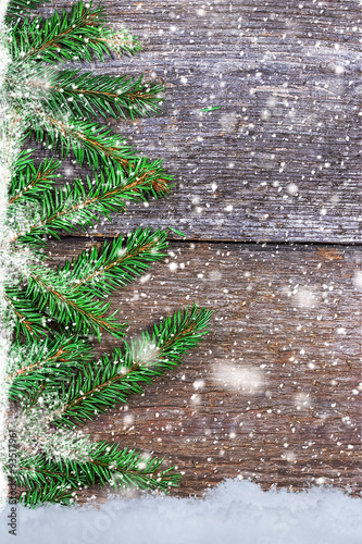 Spruce branches on wooden boards with snowflakes