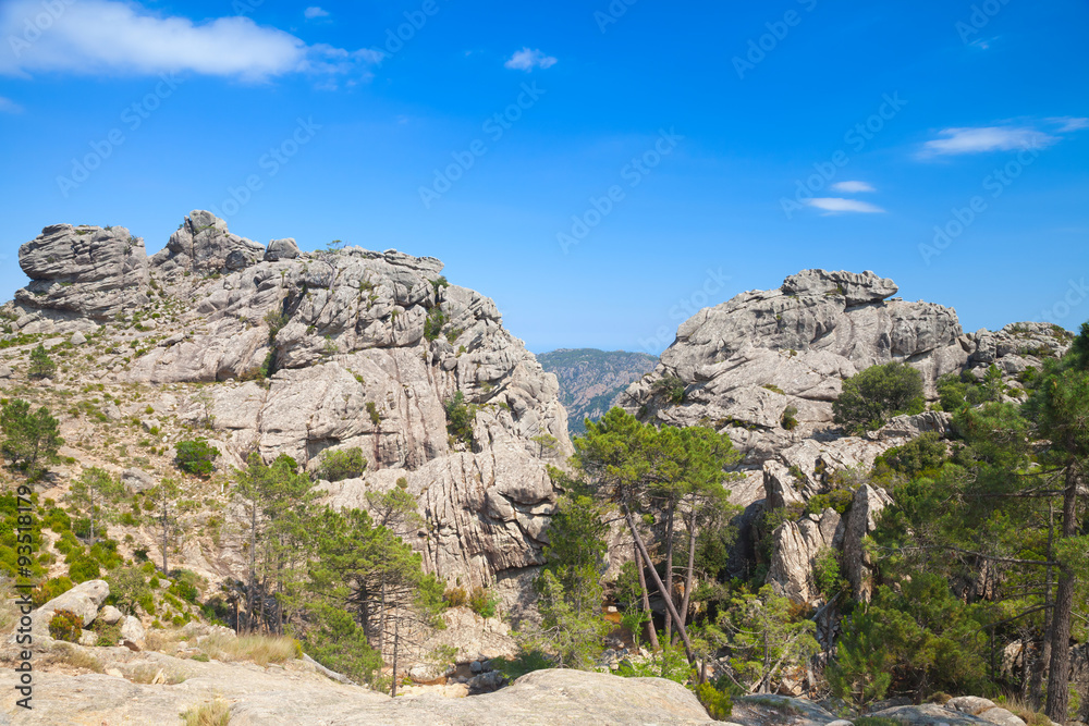 Wild mountain landscape, rocks under blue sky