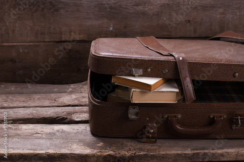 Old leather suitcase with books. photo