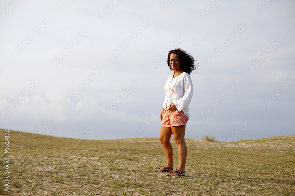 Mujer con el pelo al viento sobre la hierba