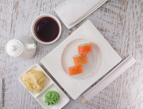 Japanese cuisine. Sushi on a white plate over vintage wooden background.