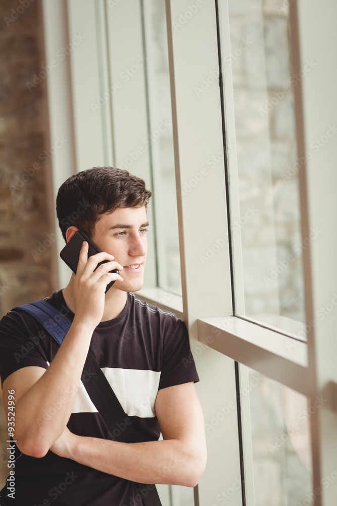 Male student talking on mobile phone in college Male student talking on mobile phone in college