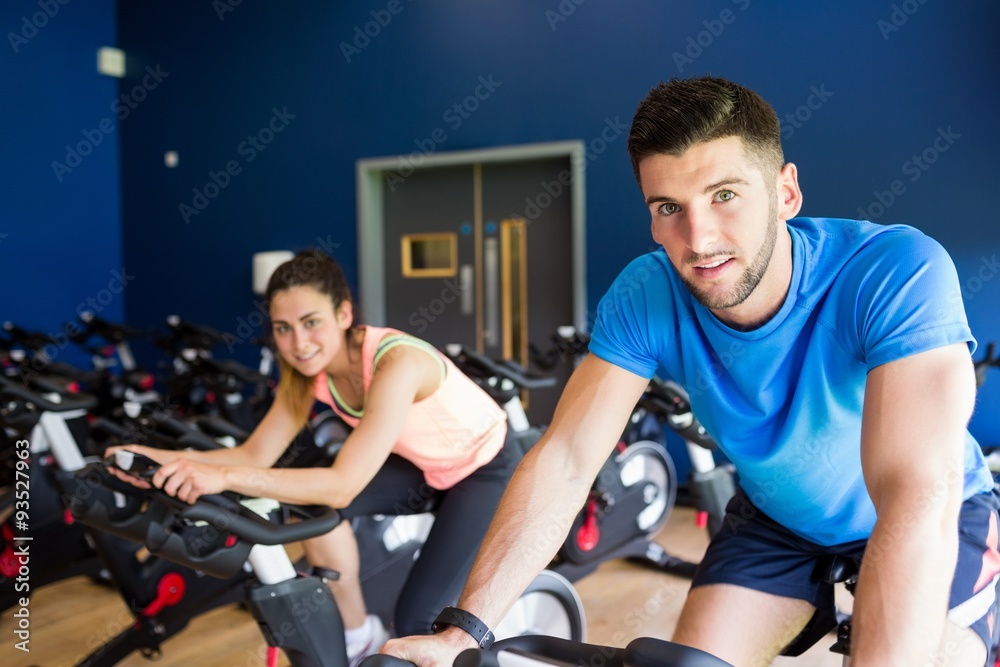 Man and woman using cycling exercise bikes Man and woman using cycling exercise bikes