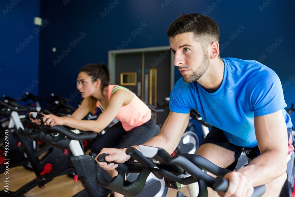 Focused man and woman on exercise bikes Focused man and woman on exercise bikes