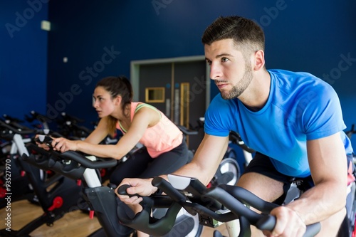 Focused man and woman on exercise bikes