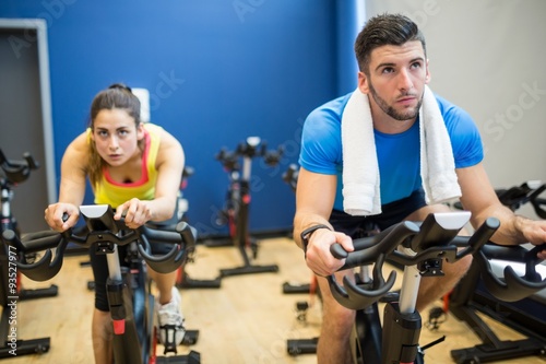 Focused couple using exercise bikes