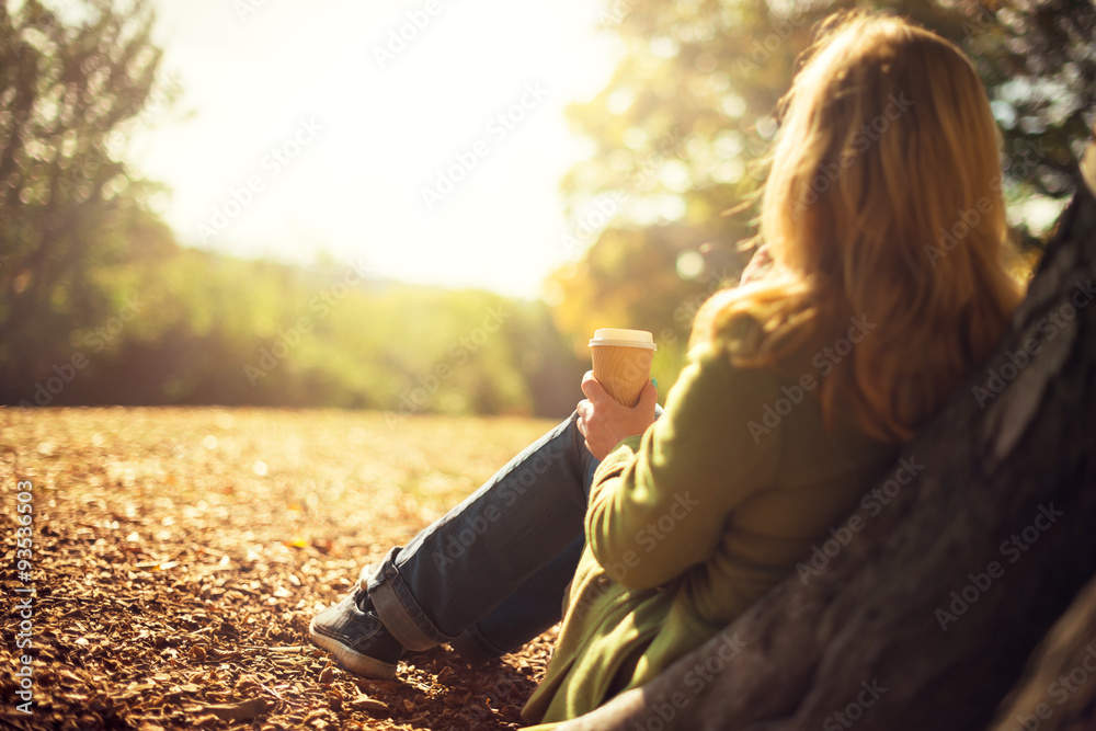 Fototapeta premium Autumn concept, anonymous woman enjoying takeaway coffee cup on sunny cols fall day