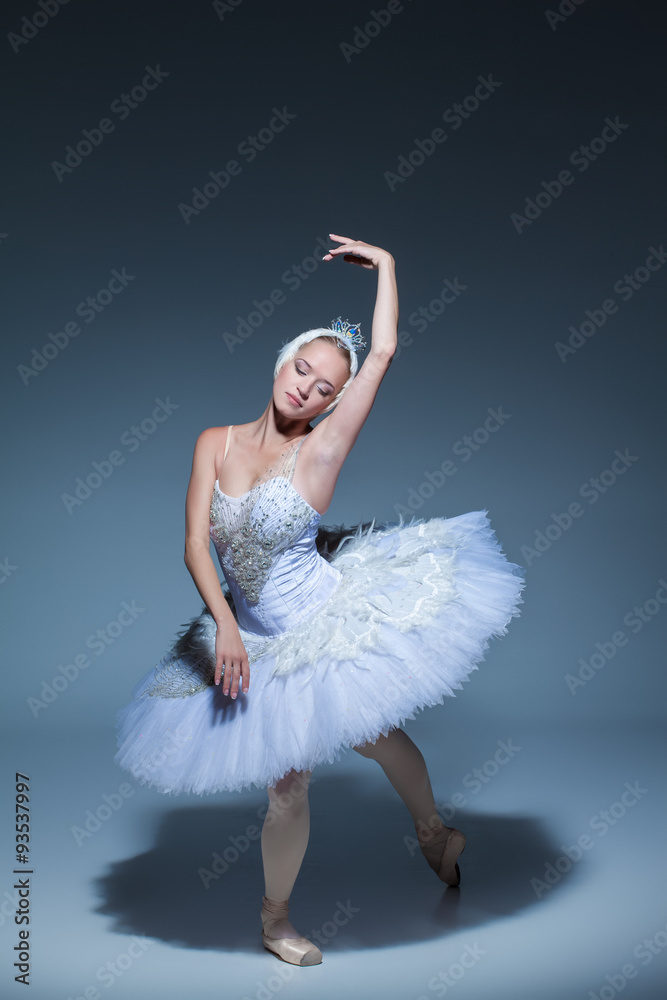 Naklejka premium Portrait of the ballerina in ballet tatu on blue background