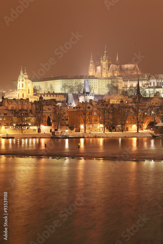 Night romantic colorful snowy Prague gothic Castle with Charles Bridge, Czech Republic