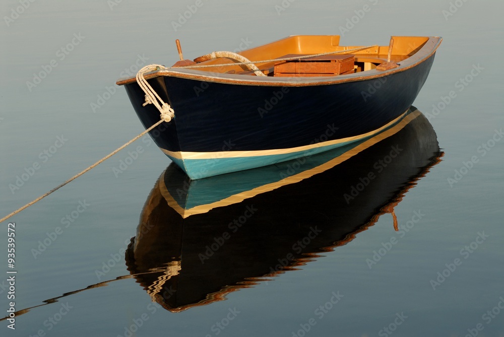 Litle boat and its reflection on the calm sea