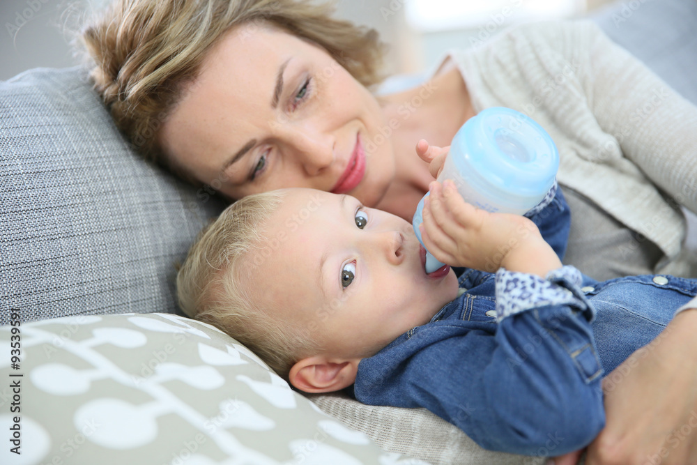 Mommy watching baby boy drinking from baby bottle Mommy watching baby boy drinking from baby bottle