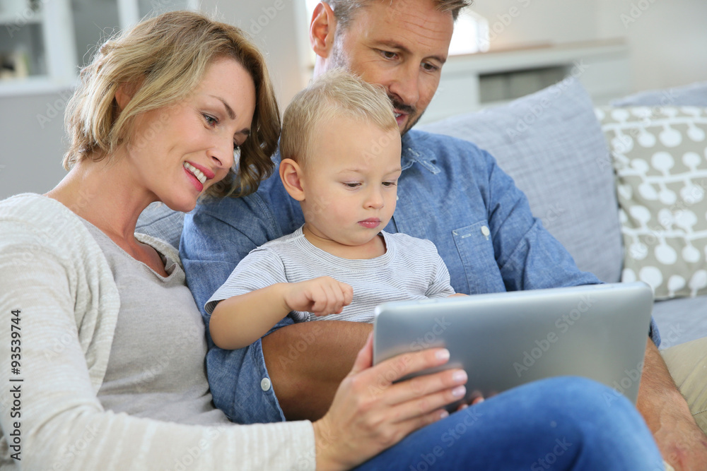 Parents with baby boy playing with digital tablet Parents with baby boy playing with digital tablet