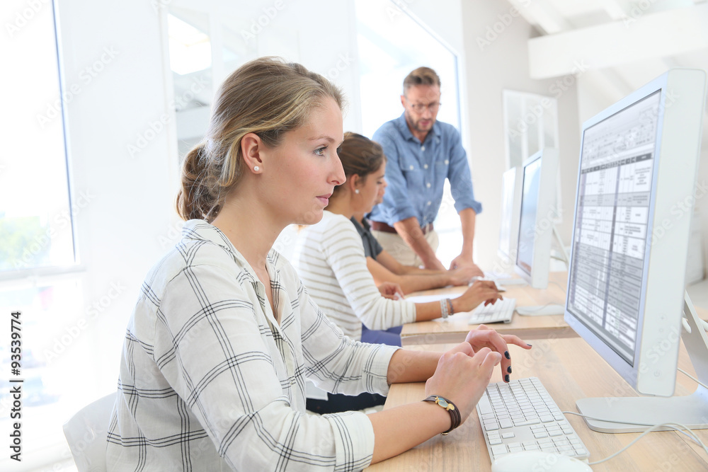 Student girl in class sitting in front of desktop computer