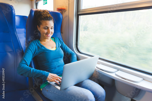 Young woman working with computer on the train