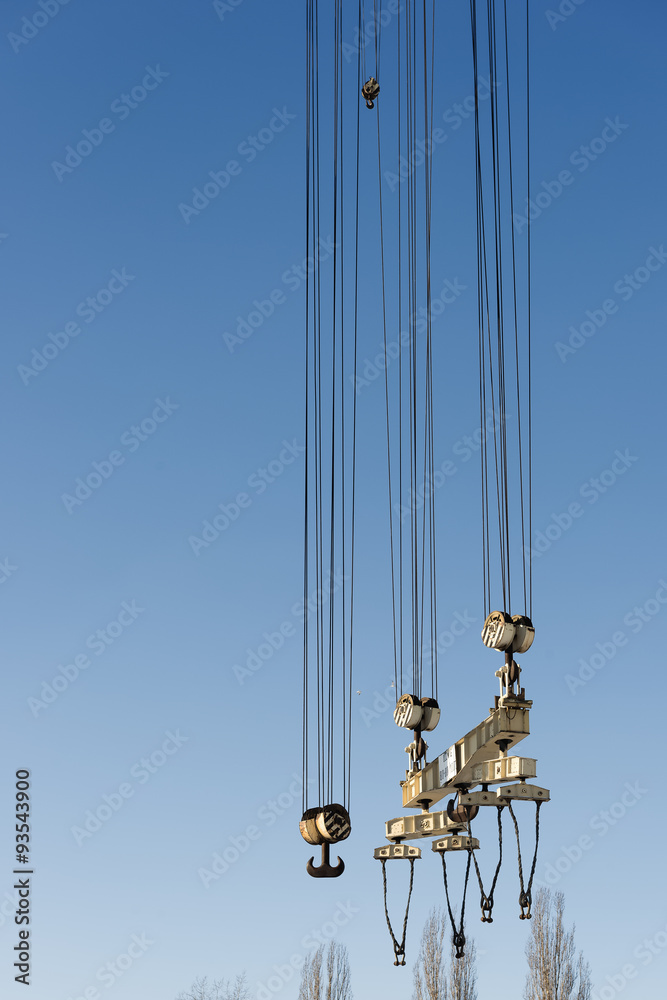 Naklejka premium Big harbor cranes hooks hanging on steel ropes.