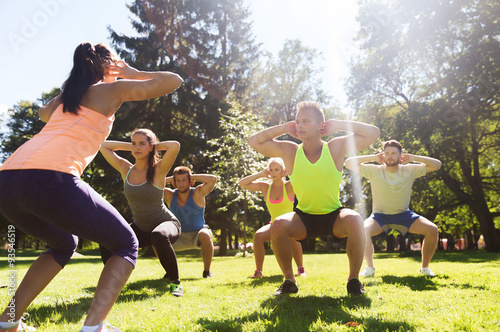 Photos group of friends or sportsmen exercising outdoors