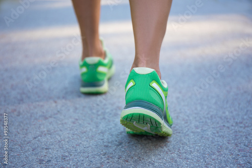 close up of female legs in sporty shoes running on road