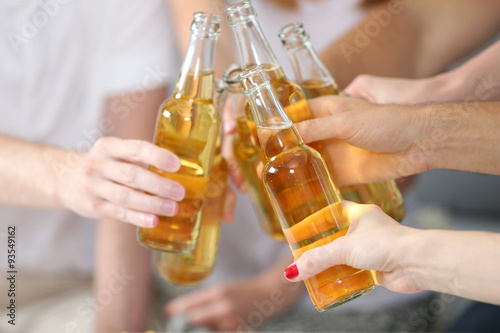 Friends hands with bottles of beer, close up