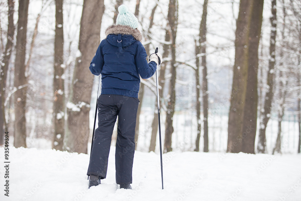 Portrait of young woman with ski in winter time