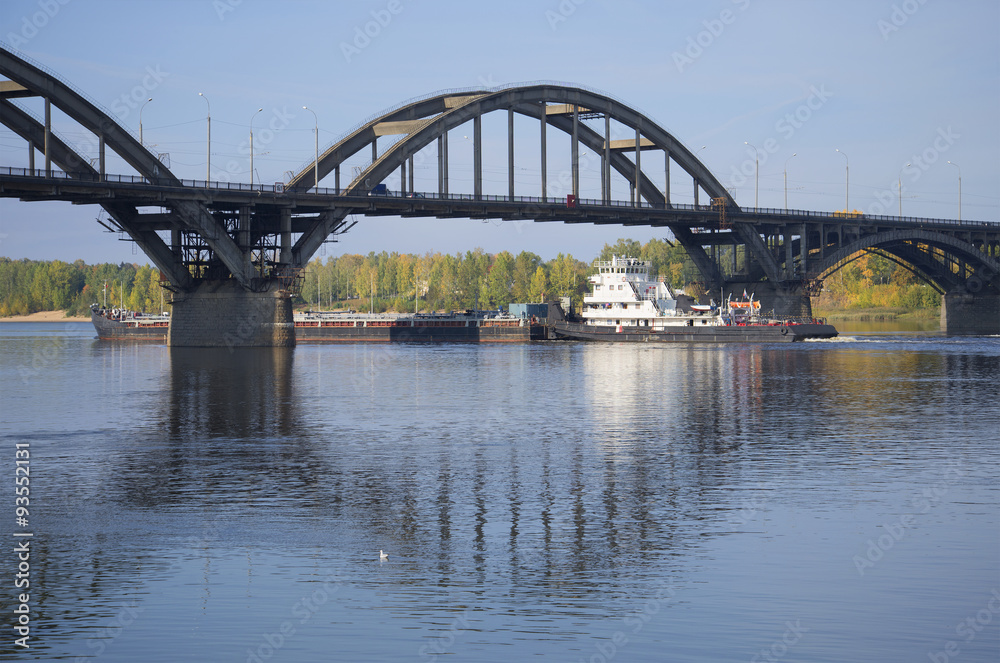 Naklejka premium Речной буксир с баржей проходит под автомобильным мостом. Рыбинск