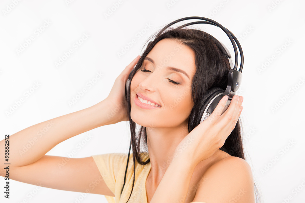 Cute young woman enjoying music on headphones, smiling and close Cute young woman enjoying music on headphones, smiling and close