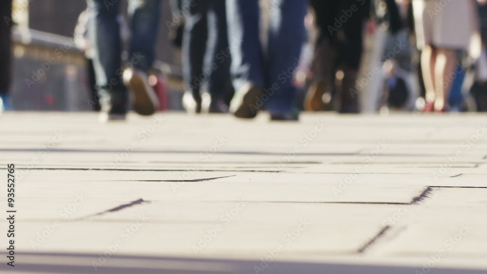 Feet of commuters walking on the pavement
