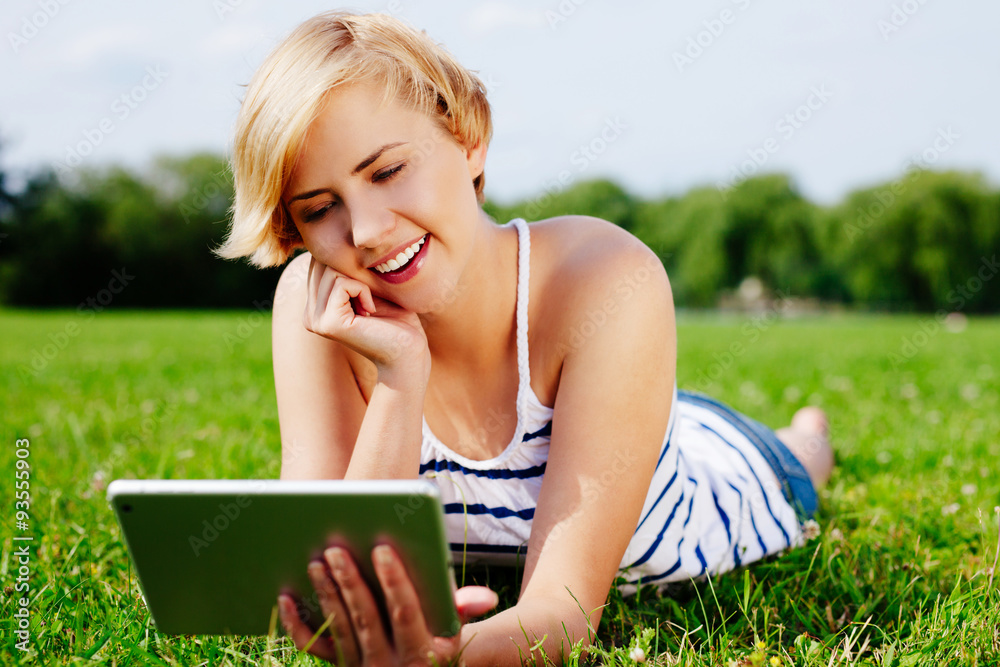 Smiling woman browsing the web on her tablet Smiling woman browsing the web on her tablet